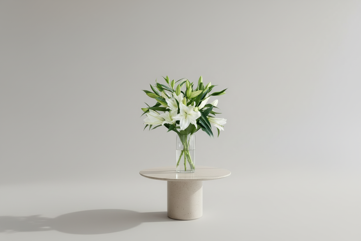 Bouquet of white lilies in a clear vase against a gray background
