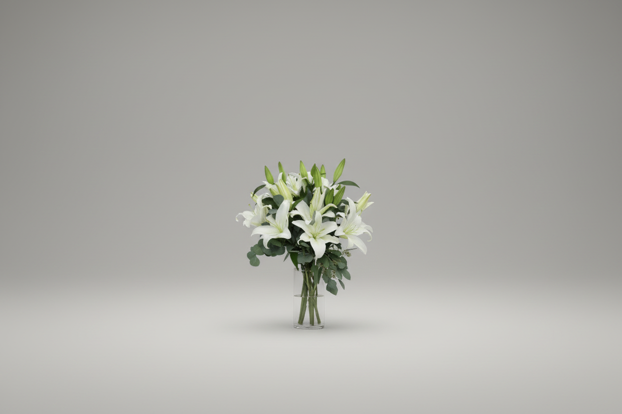 Bouquet of white flowers in a clear vase on a gray background