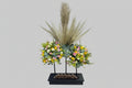 Floral arrangement with dried grasses on a black stand against a white background