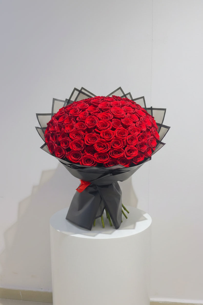 Bouquet of red roses wrapped in black paper on a white background